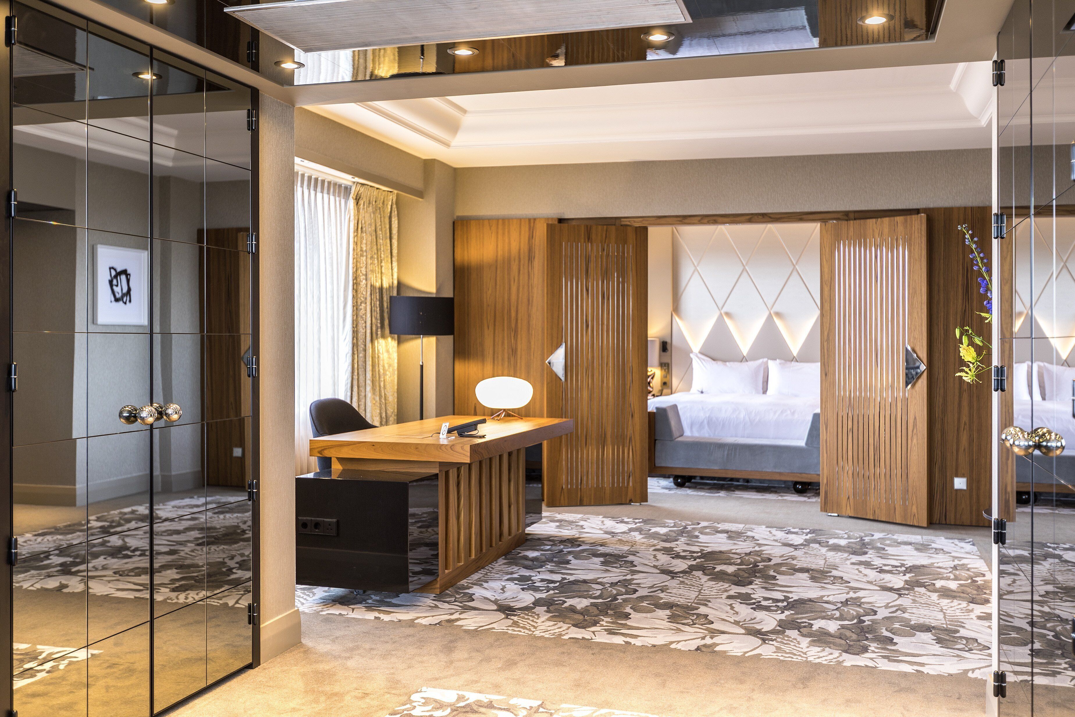Ein modernes Hotelzimmer mit einem großen Bett, einem Schreibtisch und einer Glaskabine.