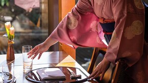 Une pièce de style japonais traditionnel, avec un sol recouvert de tatamis, une basse table en bois et un paravent coulissant de type shoji.