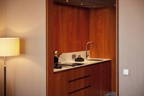A compact bathroom with a wooden vanity, a sink, and a mirror.