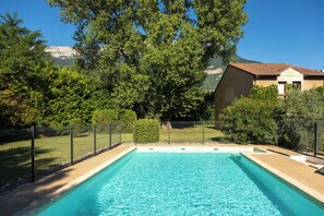 Una piscina al aire libre de temporada, sombrillas, tumbonas