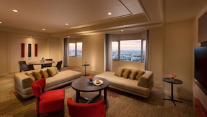 A modern hotel room with a sofa set, a dining table, and a TV. - DoubleTree by Hilton Naha Shuri Castle (Naha)