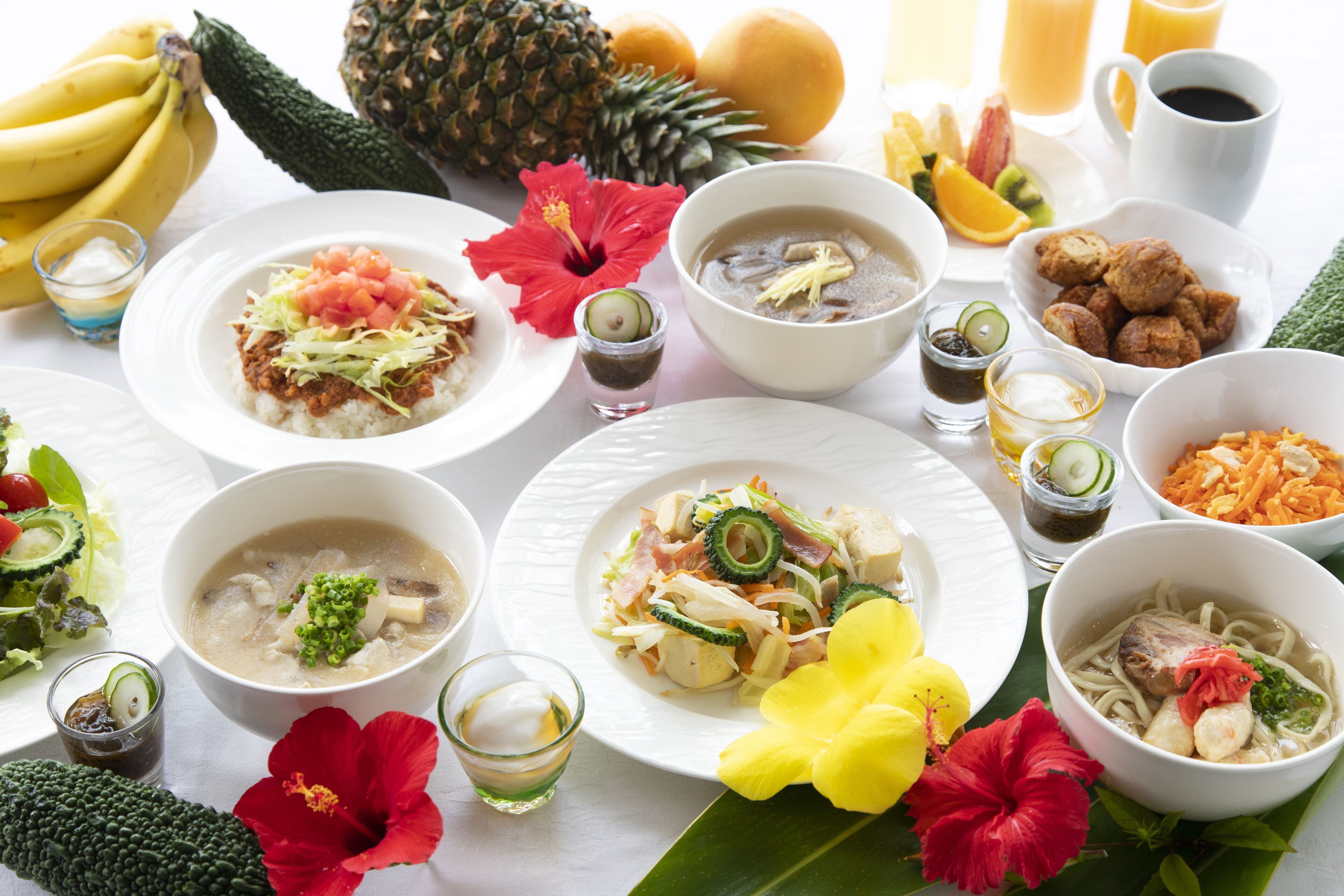 Uma mesa com diversos pratos, incluindo sopas e saladas em tigelas, além de frutas e legumes variados.