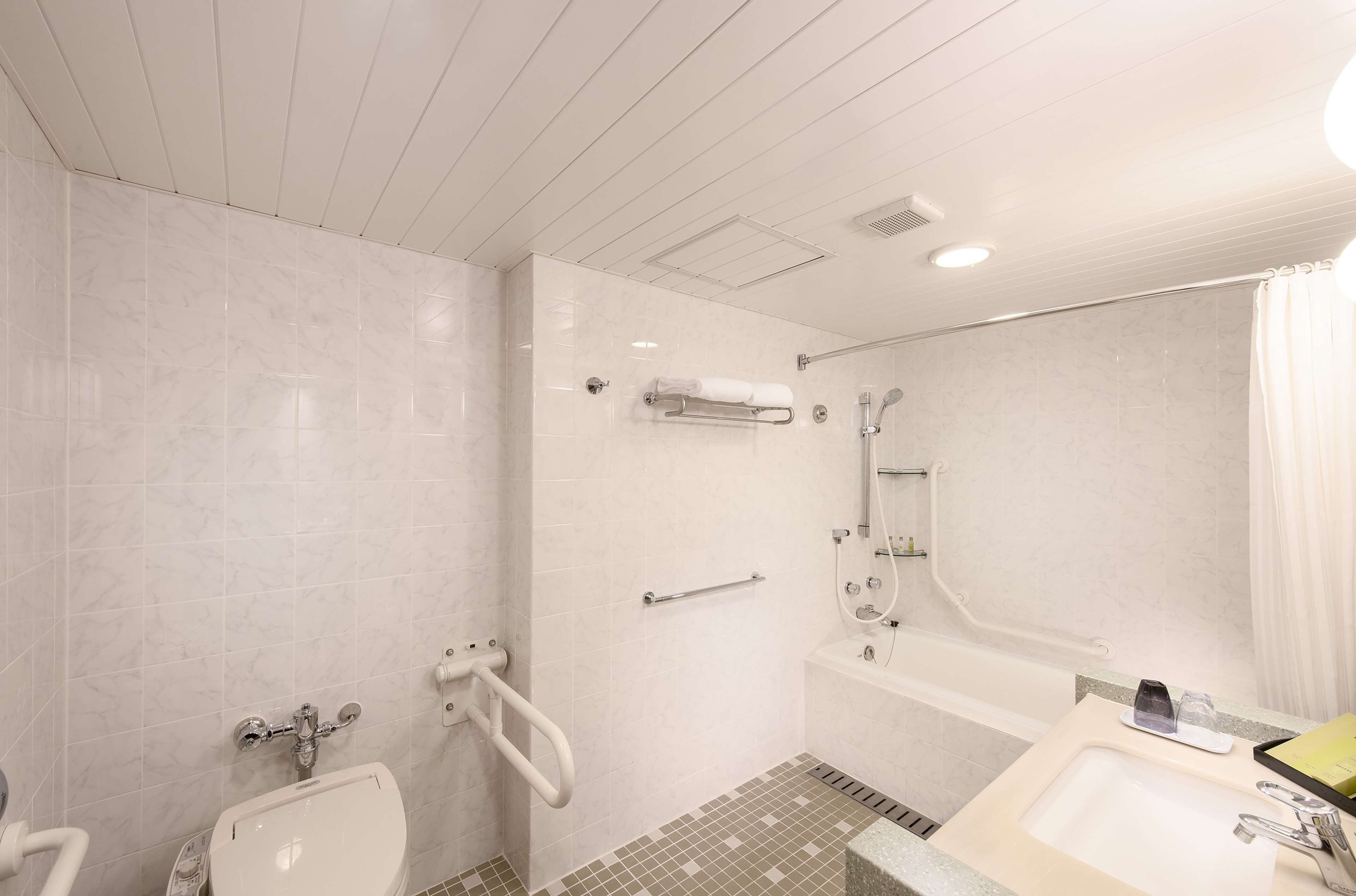 A modern bathroom with a shower, toilet, and sink.
