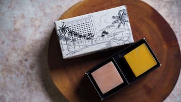 A box with a tropical cityscape design and two shades of powder.