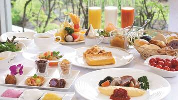 Una mesa dispuesta con diversos alimentos para el desayuno, como waffles, huevos y pasteles, con vistas a árboles al fondo.