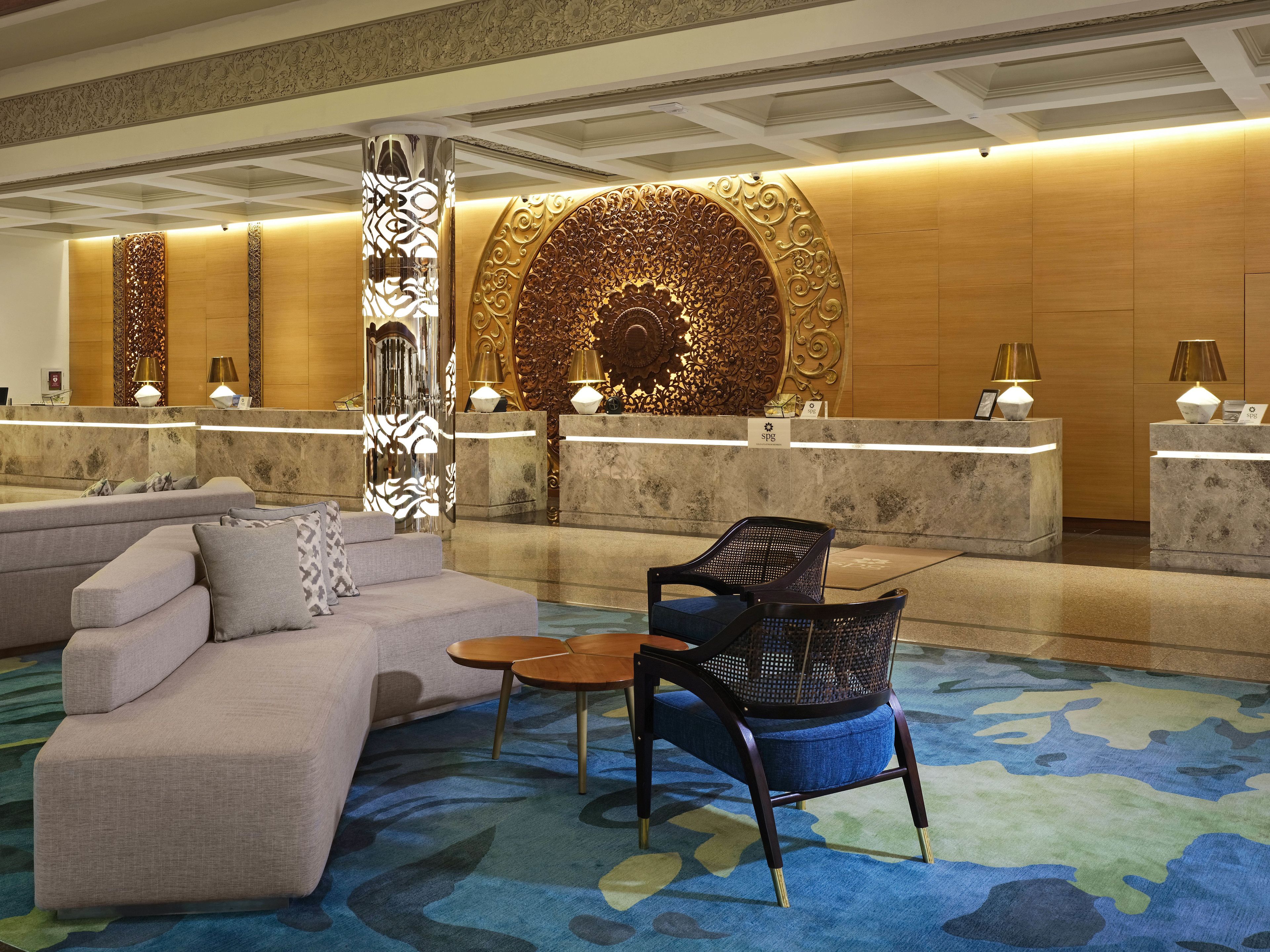 A lobby with a reception desk, a sofa, and a chair.