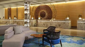 A lobby with a reception desk, a sofa, and a chair.