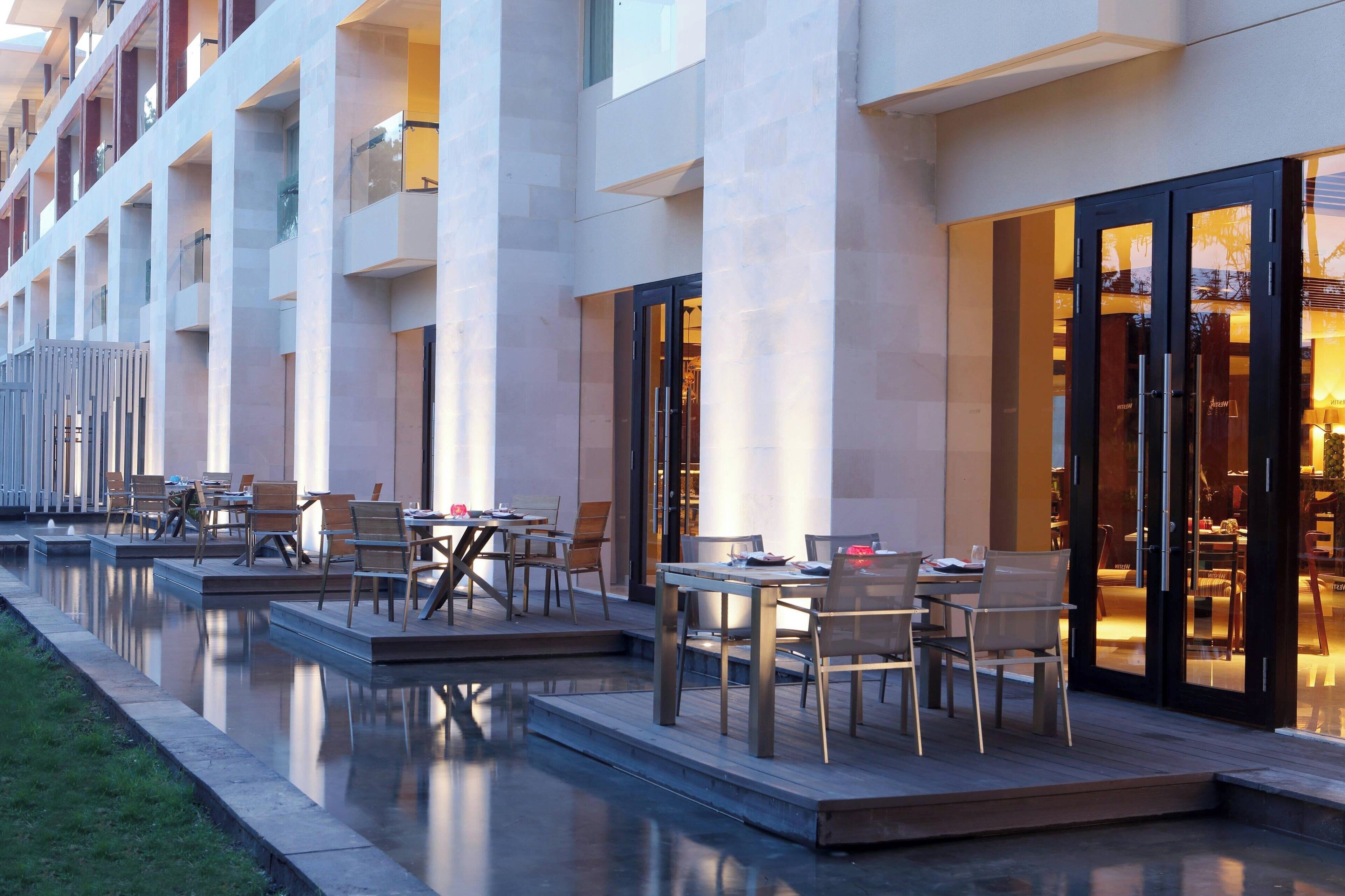 A modern hotel with outdoor seating areas and a pool.