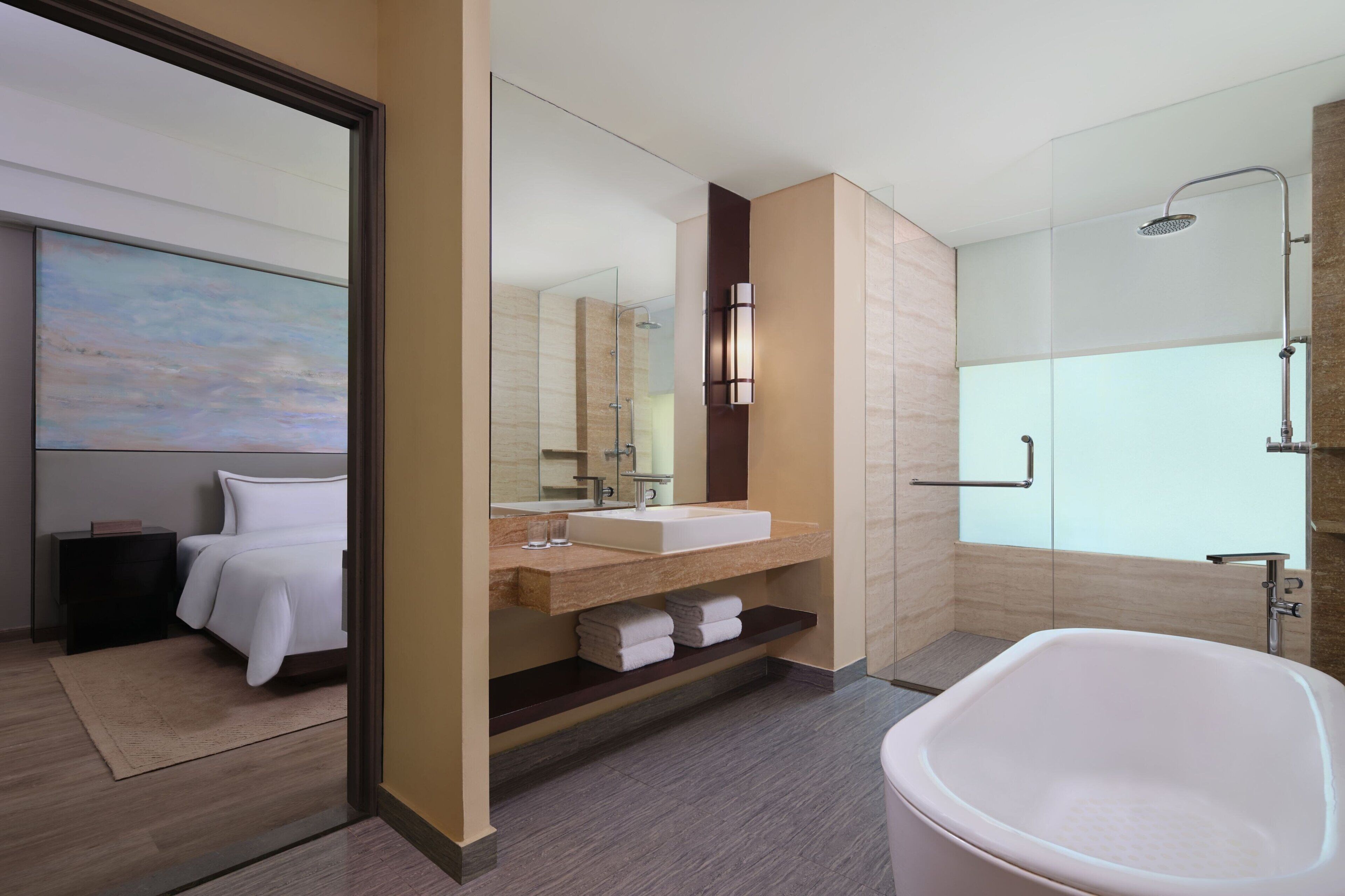 A modern bathroom with a large bathtub, a glass shower enclosure, and a vanity with a mirror and sink.