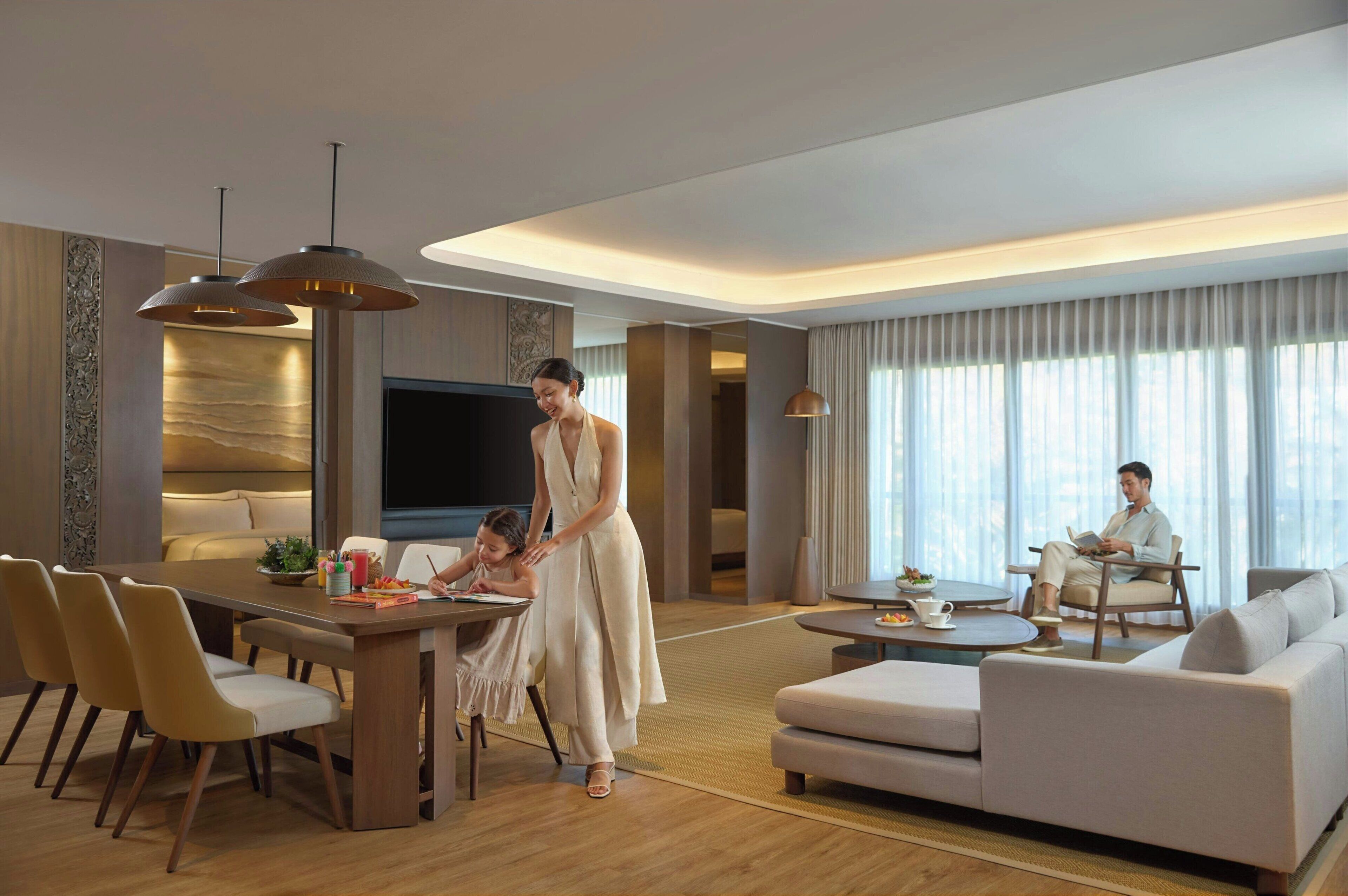 A modern hotel living room with a dining area, a sofa set, and a TV.