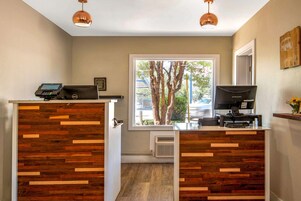 Un mostrador de recepción de diseño moderno, con un patrón de paneles de madera y un terminal de pago digital.