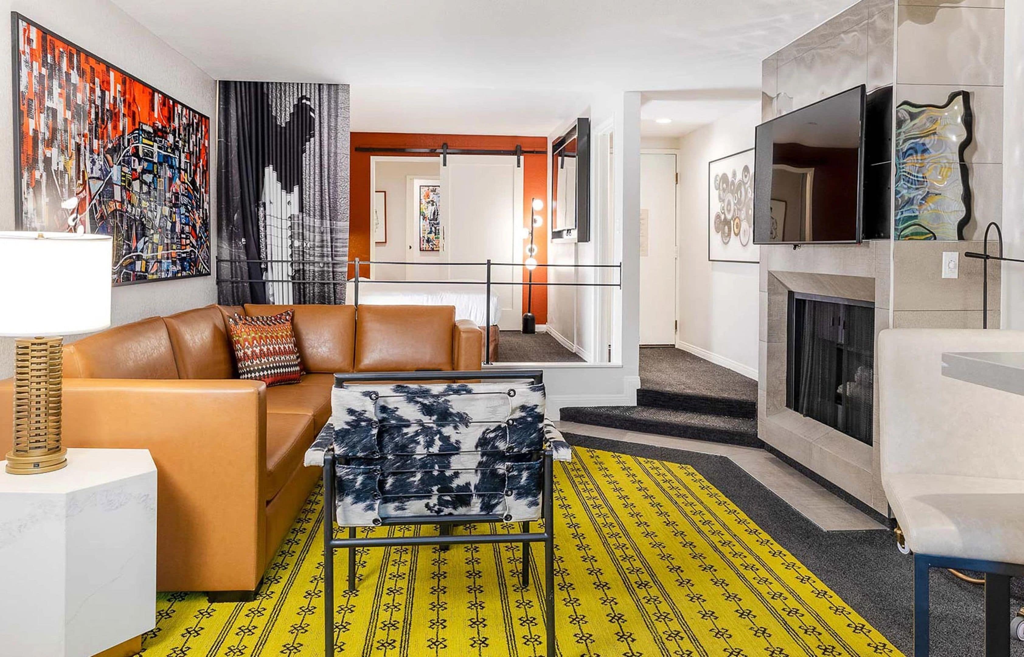 A modern living room with a sofa, a patterned coffee table, and a fireplace.