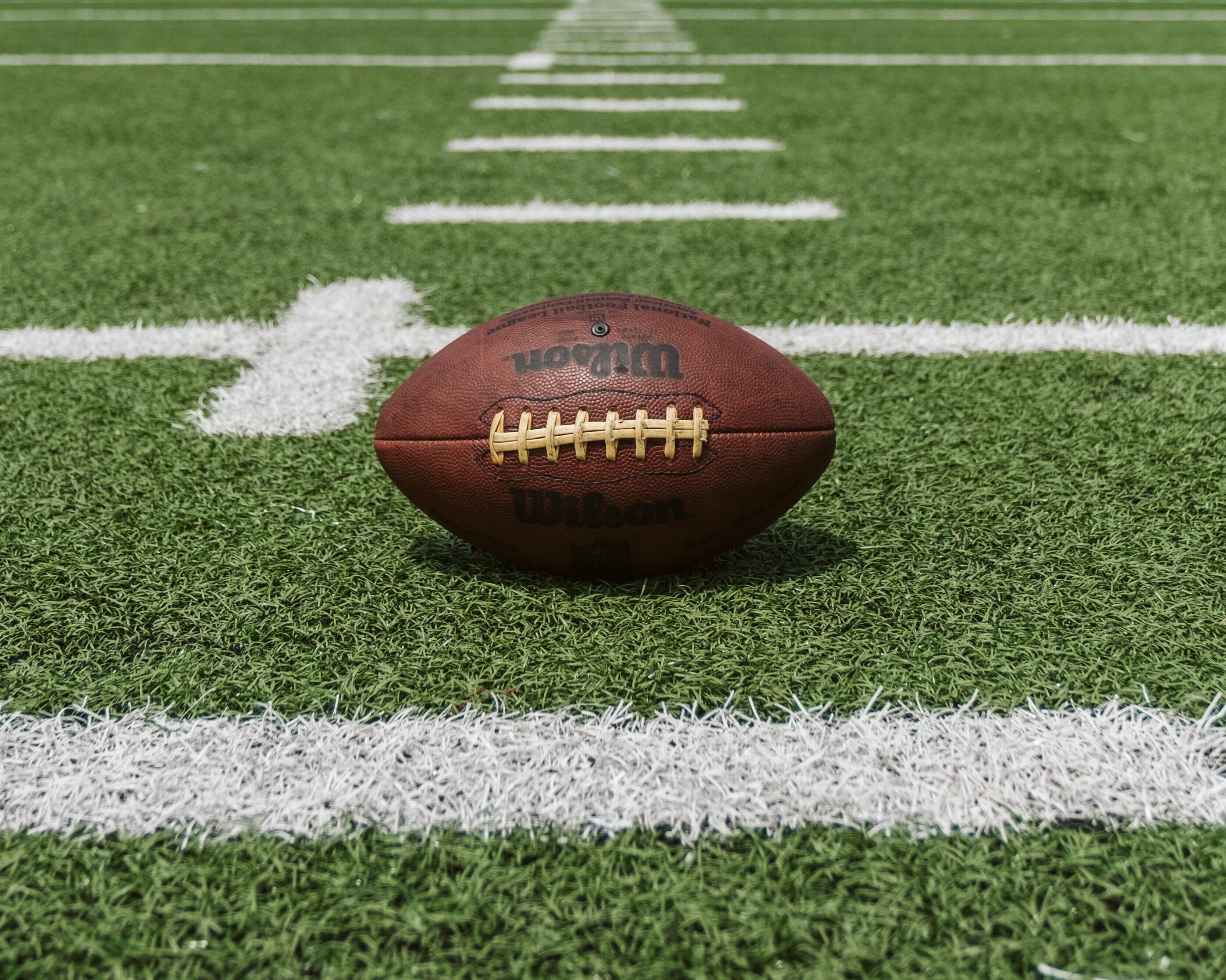 A football on a field with white lines.