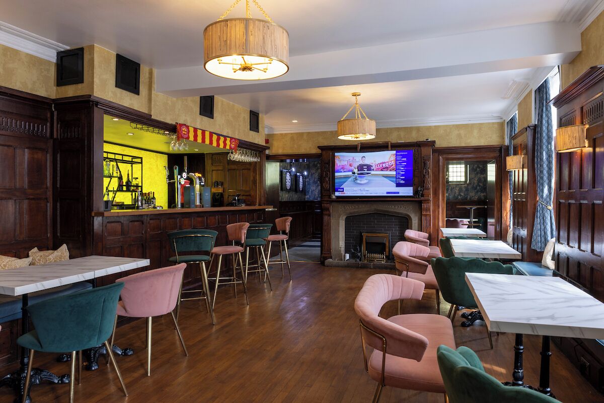 Un área de bar con mobiliario de madera, un televisor y una chimenea.