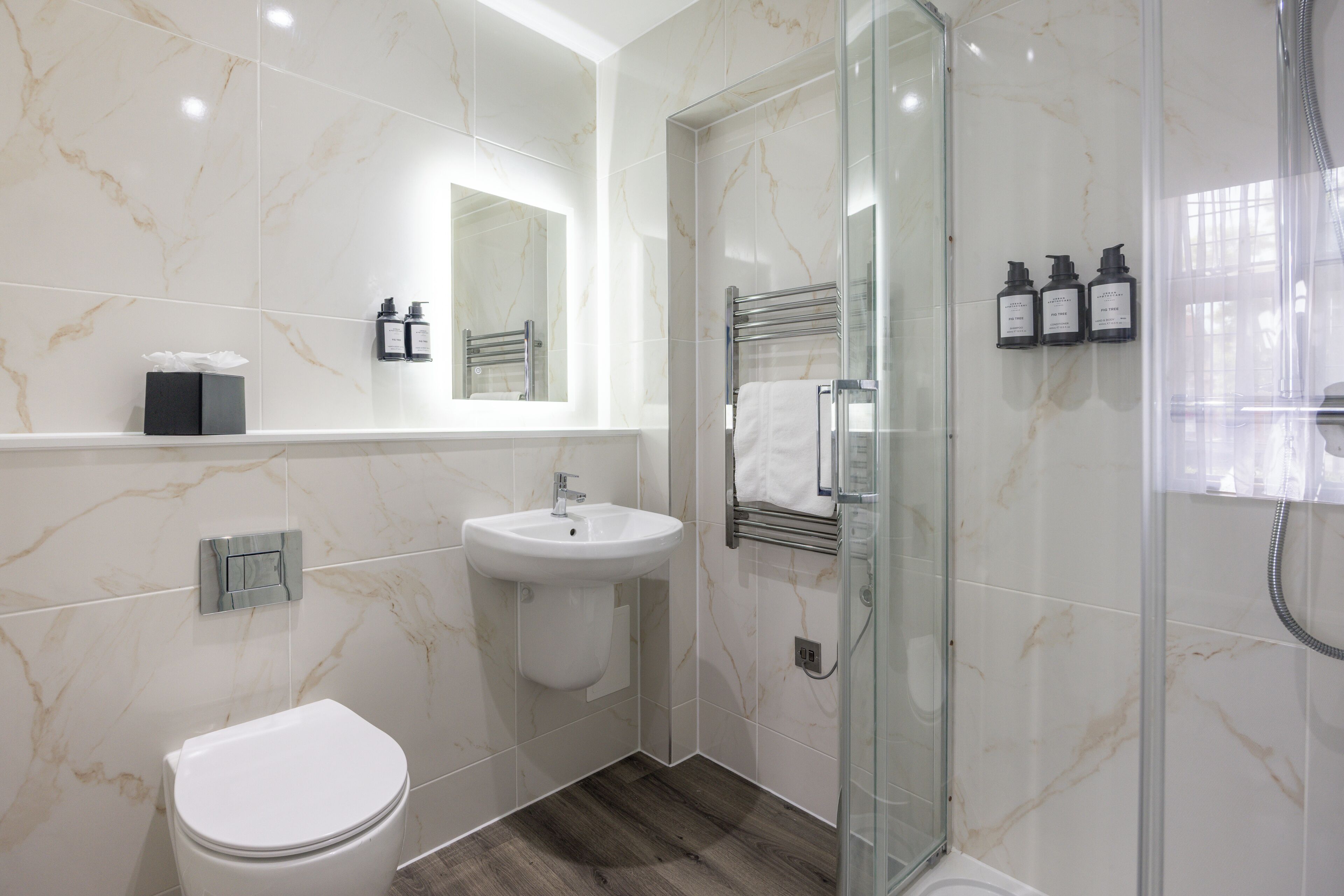 Une salle de bain moderne avec une douche à parois de verre, un lavabo blanc et des toilettes.