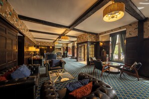 A spacious lobby with leather sofas, a coffee table, and a patterned carpet.