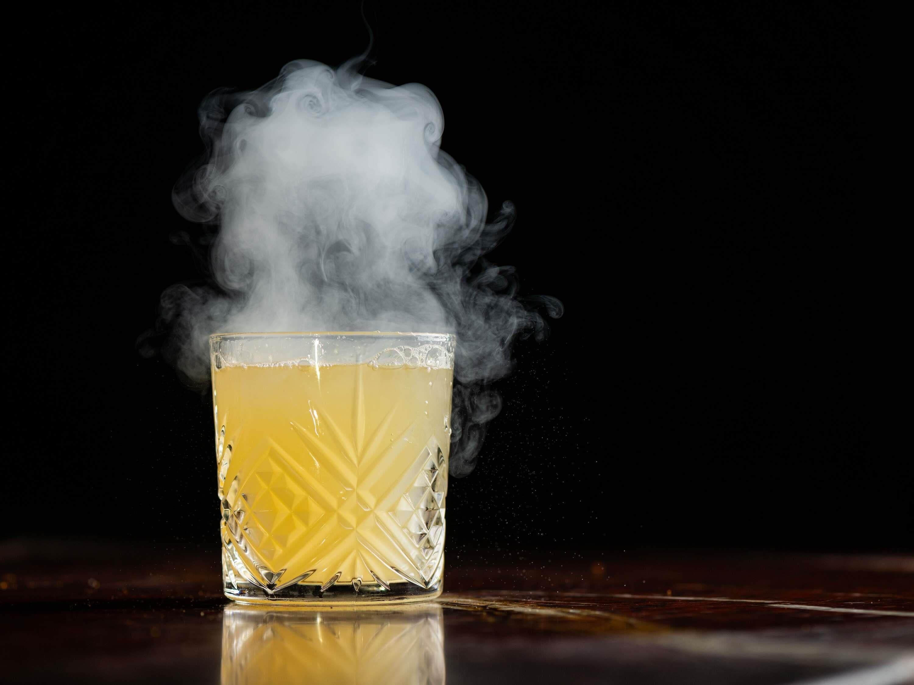 Un verre contenant un liquide jaune, dont s’échappe de la vapeur.