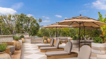 Una piscina al aire libre, sillones reclinables de piscina