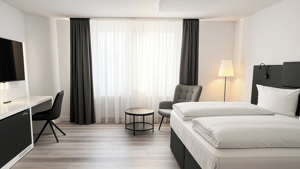 A hotel room with a bed, a desk, a chair, a lamp, and a TV. - Dormero Hotel Dessau-Rosslau (Dessau-Rosslau)