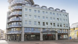 A multi-story hotel with a modern design, featuring a curved facade and multiple balconies. - Dormero Hotel Dessau-Rosslau (Dessau-Rosslau)