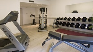 A gym with treadmills, weight machines, and a rack of dumbbells. - Dormero Hotel Dessau-Rosslau (Dessau-Rosslau)