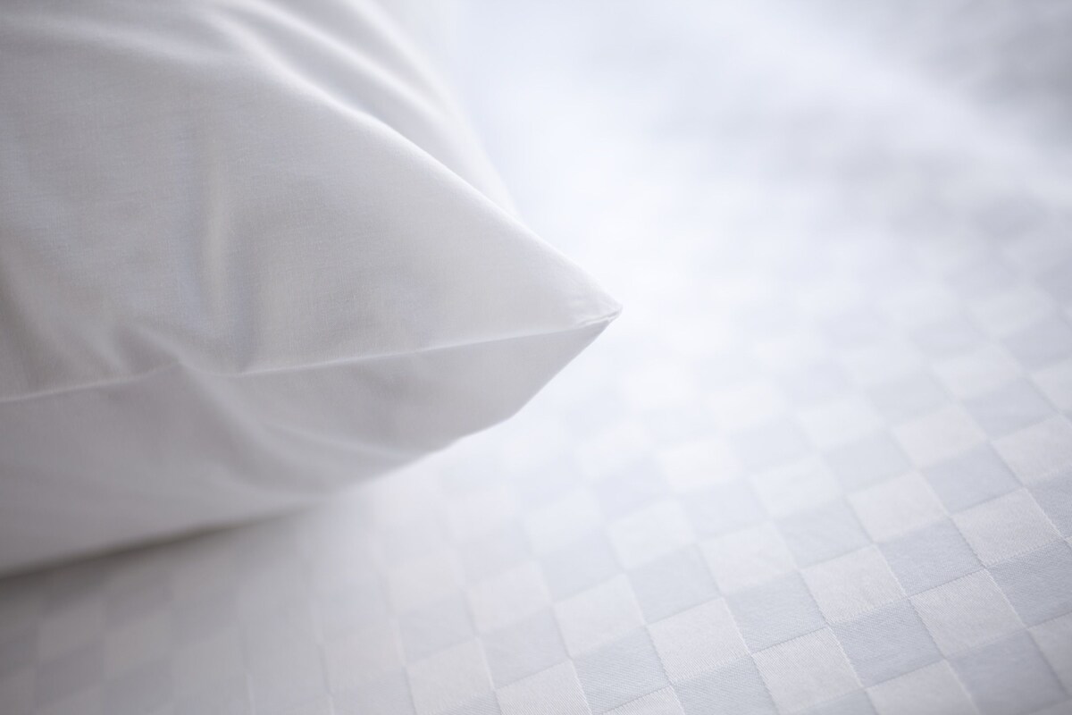 Ein Kissen auf einem Bett mit einem Karomuster.