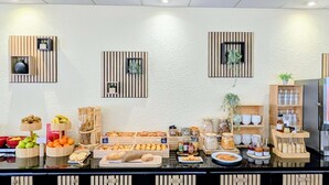 Montaje tipo bufé con diversas opciones de comida, decoración de madera y un refrigerador.