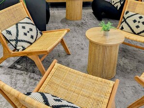 A seating area with wicker chairs and a round wooden table, featuring a small plant on the table. - Ibis Grenoble Centre Bastille (Grenoble)