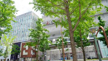 A modern building with a glass facade and a sign for 'PARC'.