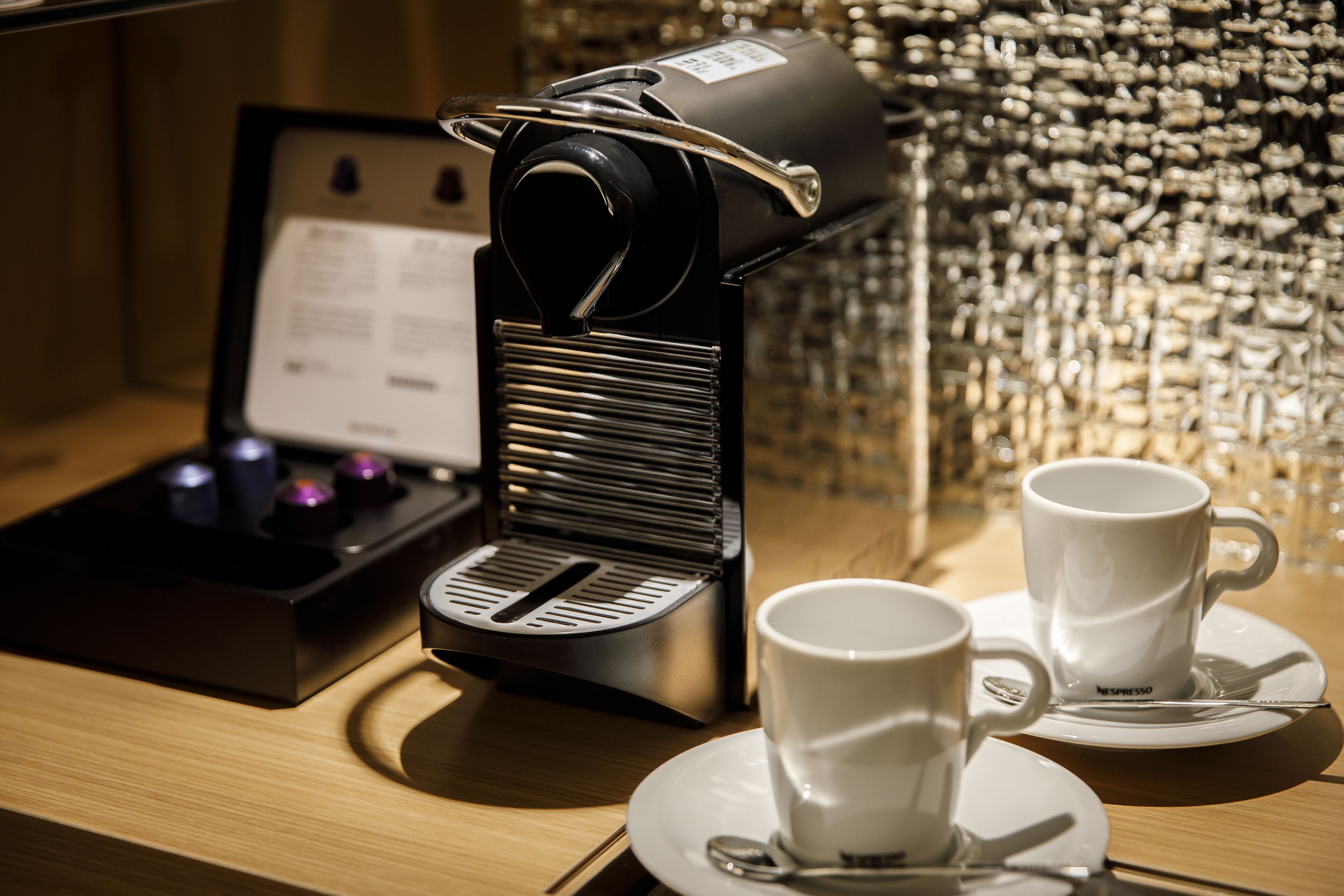 Une machine à café avec deux tasses posées sur un plateau.