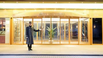 A hotel entrance with a sign reading "hotel nikko osaka".