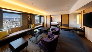 Habitación de hotel moderna con vistas a la ciudad, un sofá, una cama, un escritorio y un televisor.