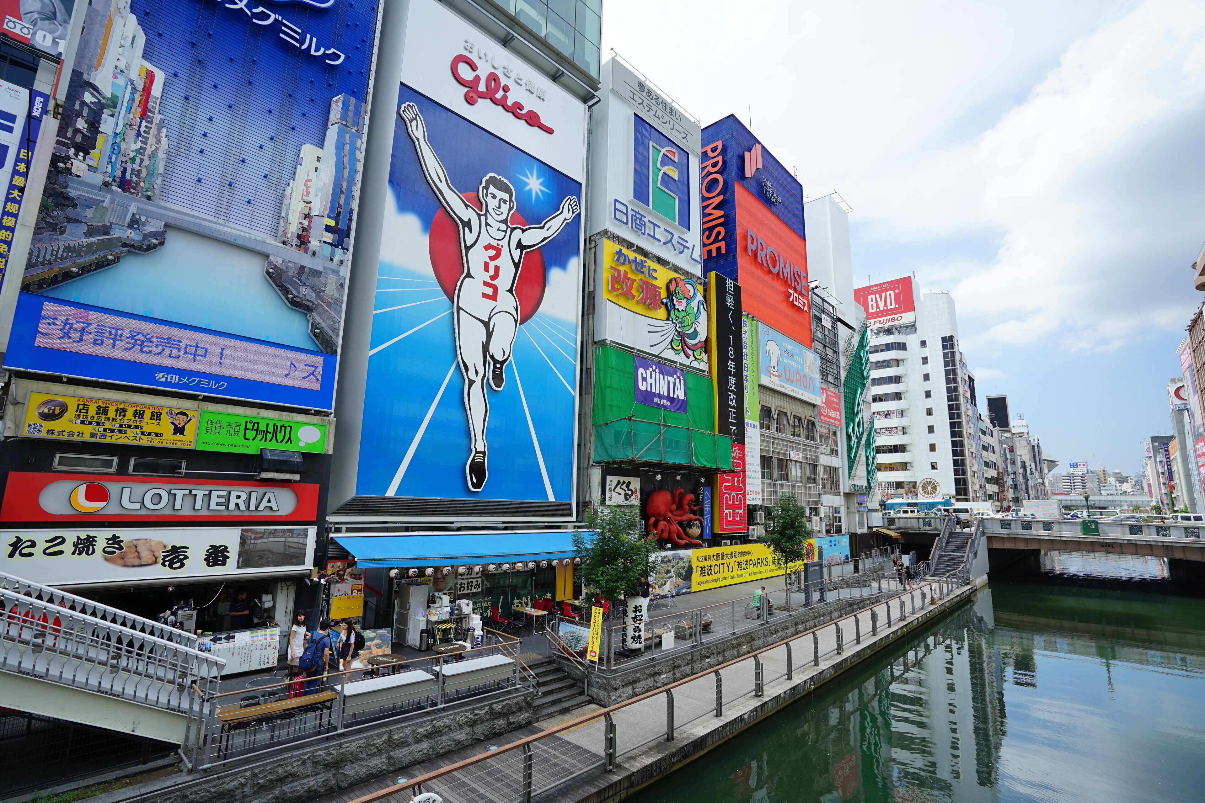 A busy urban street with large billboards and advertisements.