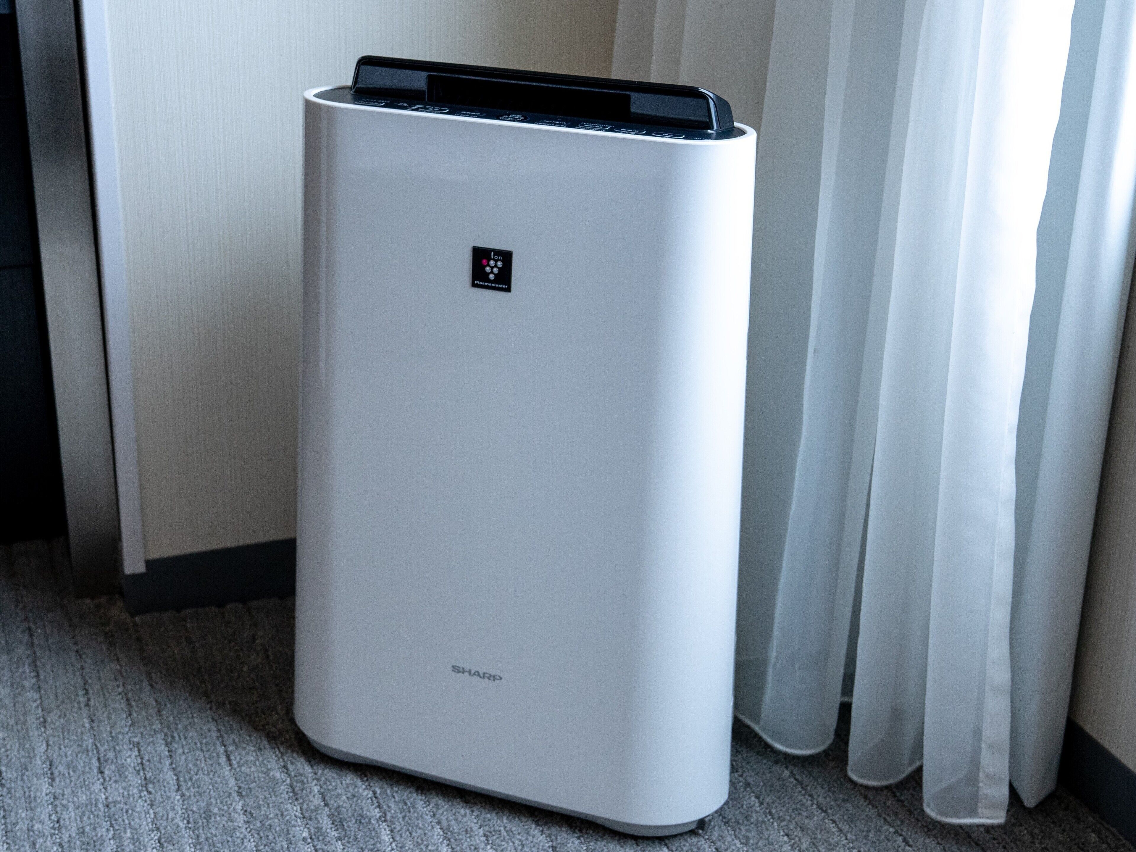 A white, modern air conditioning unit with a control panel and the brand name 'SHARP' visible.