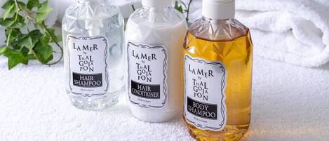 Three bottles of Lamer by Thai Goja Pon hair and body shampoo on a white towel.