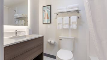 A modern bathroom with a sink, vanity, toilet, and towel rack.
