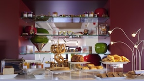 Un bufé con diversos alimentos, como pasteles, pan y salsas.