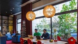 A modern interior with a wooden table, red chairs, and two hanging lamps. - Hôtel Mercure Strasbourg Centre (Strasbourg)