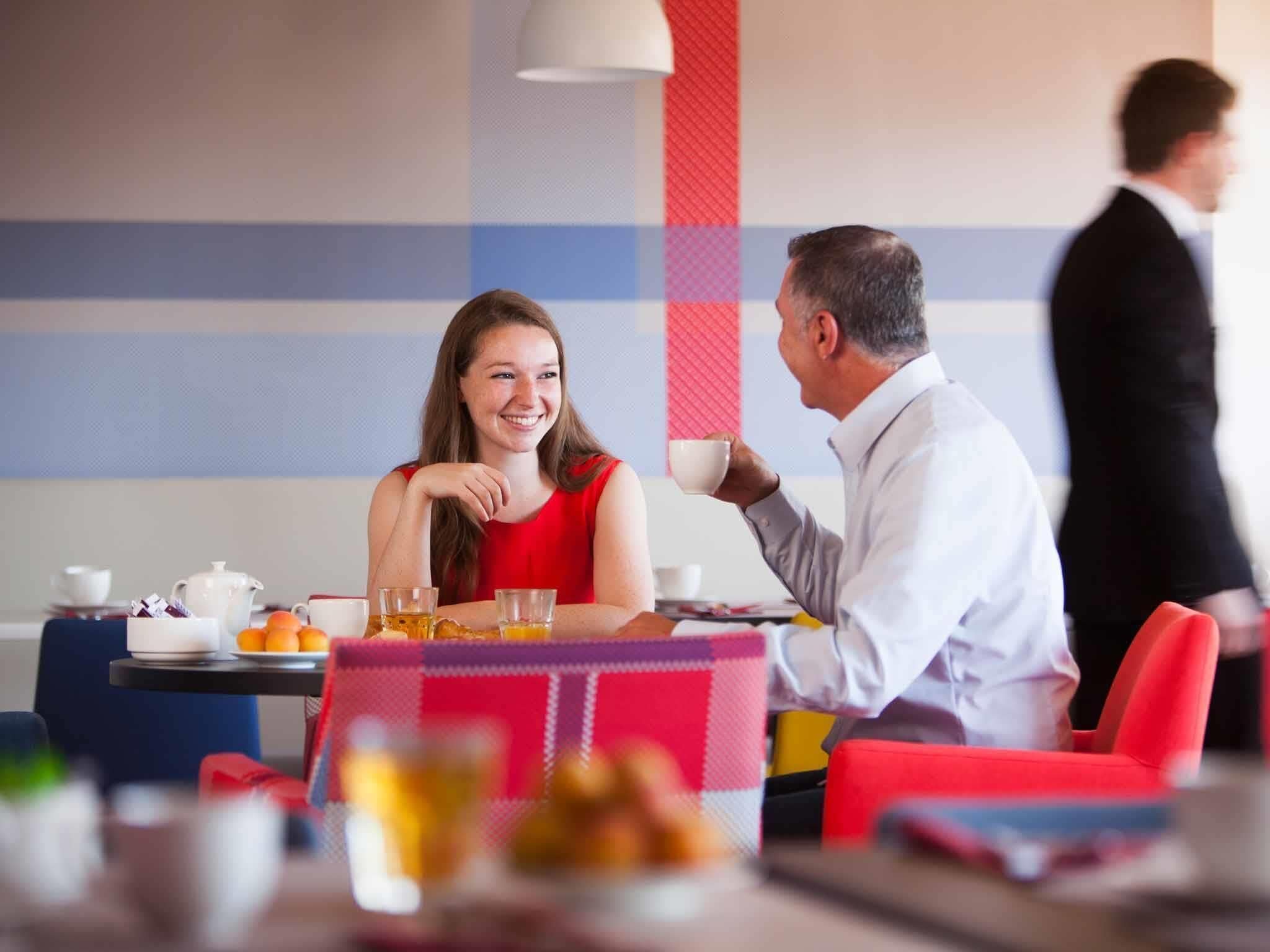 A dining area with a table set for two, a dessert plate, and a coffee cup.