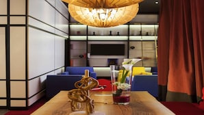 A modern interior with a wooden table, a decorative glass vase with flowers, and a unique ceiling light fixture. - Hôtel Mercure Strasbourg Centre (Strasbourg)