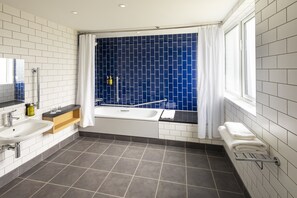 Chambre Standard, 1 grand lit, baignoire adaptée aux personnes à mobilité réduite | Salle de bain | Ensemble baignoire-douche, articles de toilette écologiques