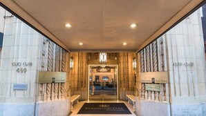 La entrada al Kensington Park Hotel, con fachada de mármol, felpudo negro y un letrero con el nombre del hotel.