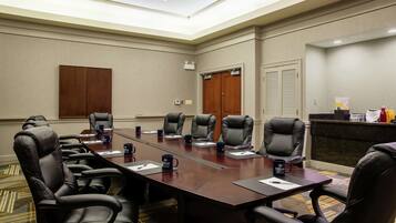 A conference room with a long table, multiple chairs, and a reception desk.