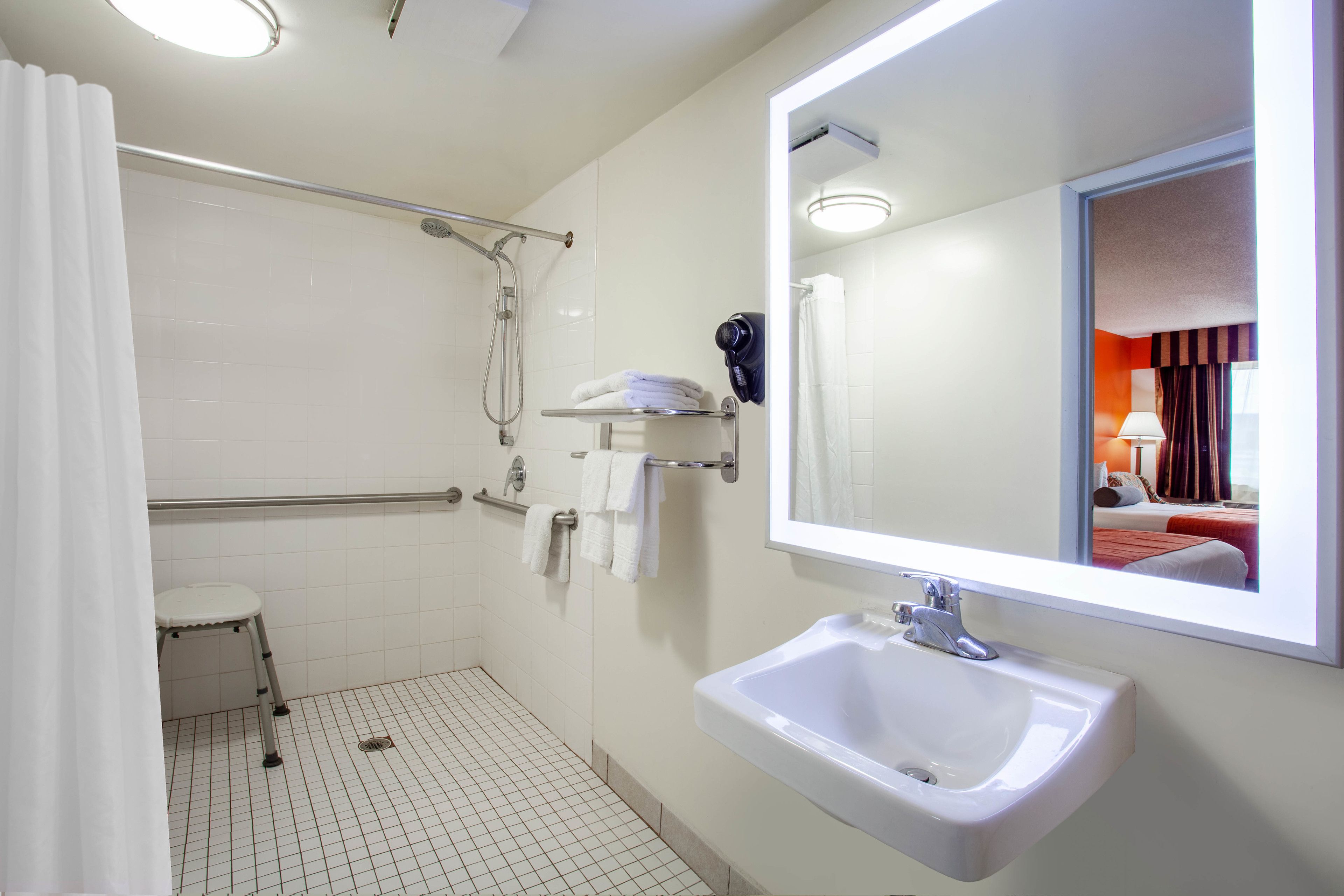 Ein modernes Badezimmer mit Waschbecken, Spiegel und Duschbereich.