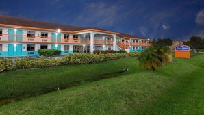 Un motel con una estructura de dos pisos, una piscina y un letrero que dice 'Howard Johnson'.