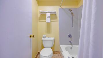 A bathroom with a toilet, a shower, and a bathtub.