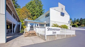Hotel 'Stevenson Inn' met een overdekte ingang, een trap die naar de tweede verdieping leidt, en een omheind buitengebied.
