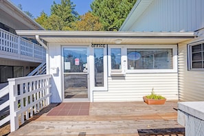 A small, single-story building with a white exterior and a porch. It has a sign that reads "OFFICE" above the entrance.