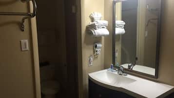 A bathroom with a white sink, a mirror, a towel rack, and a toilet.