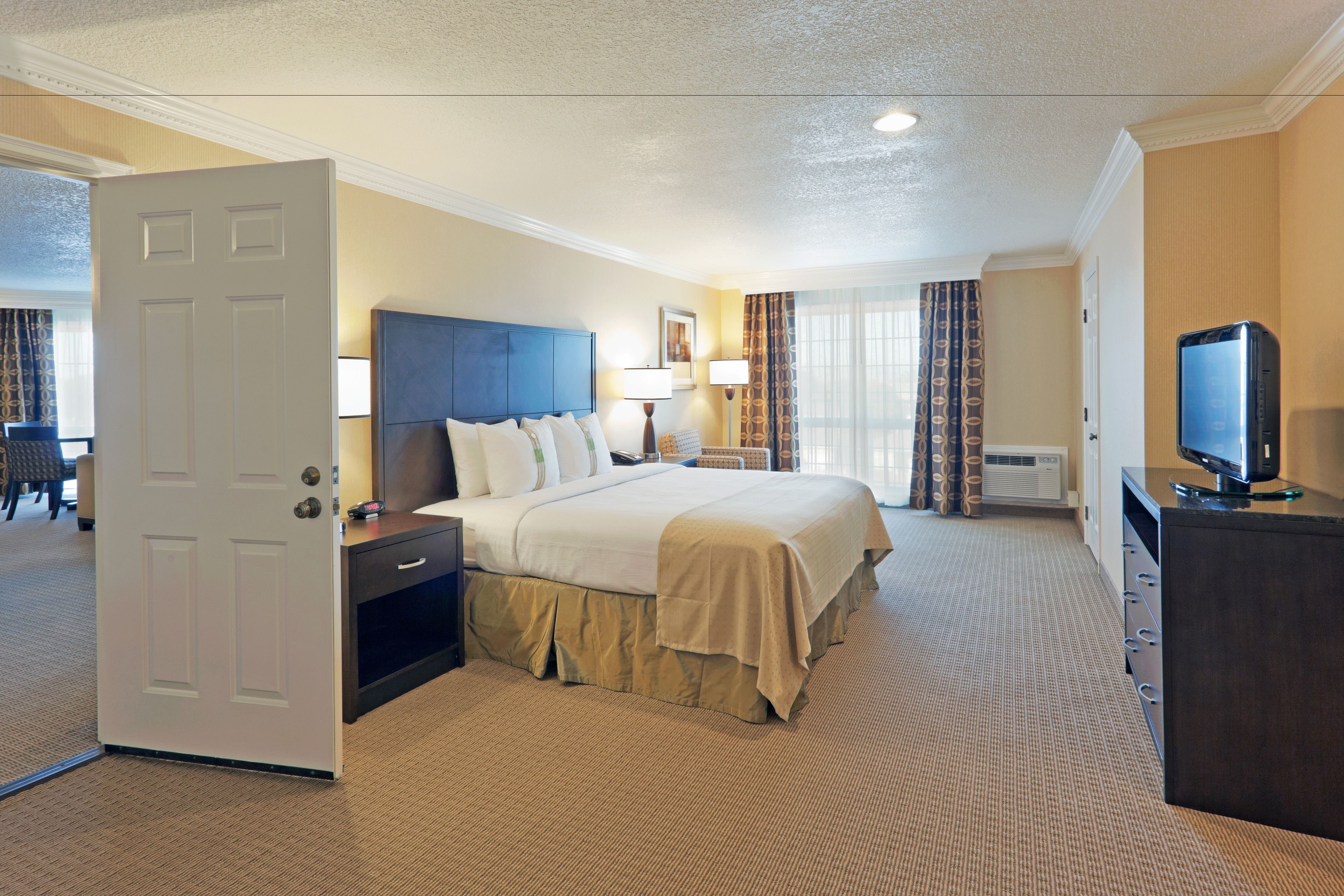Ein Hotelzimmer mit Bett, Nachttischen, Fernseher und Schreibtisch.